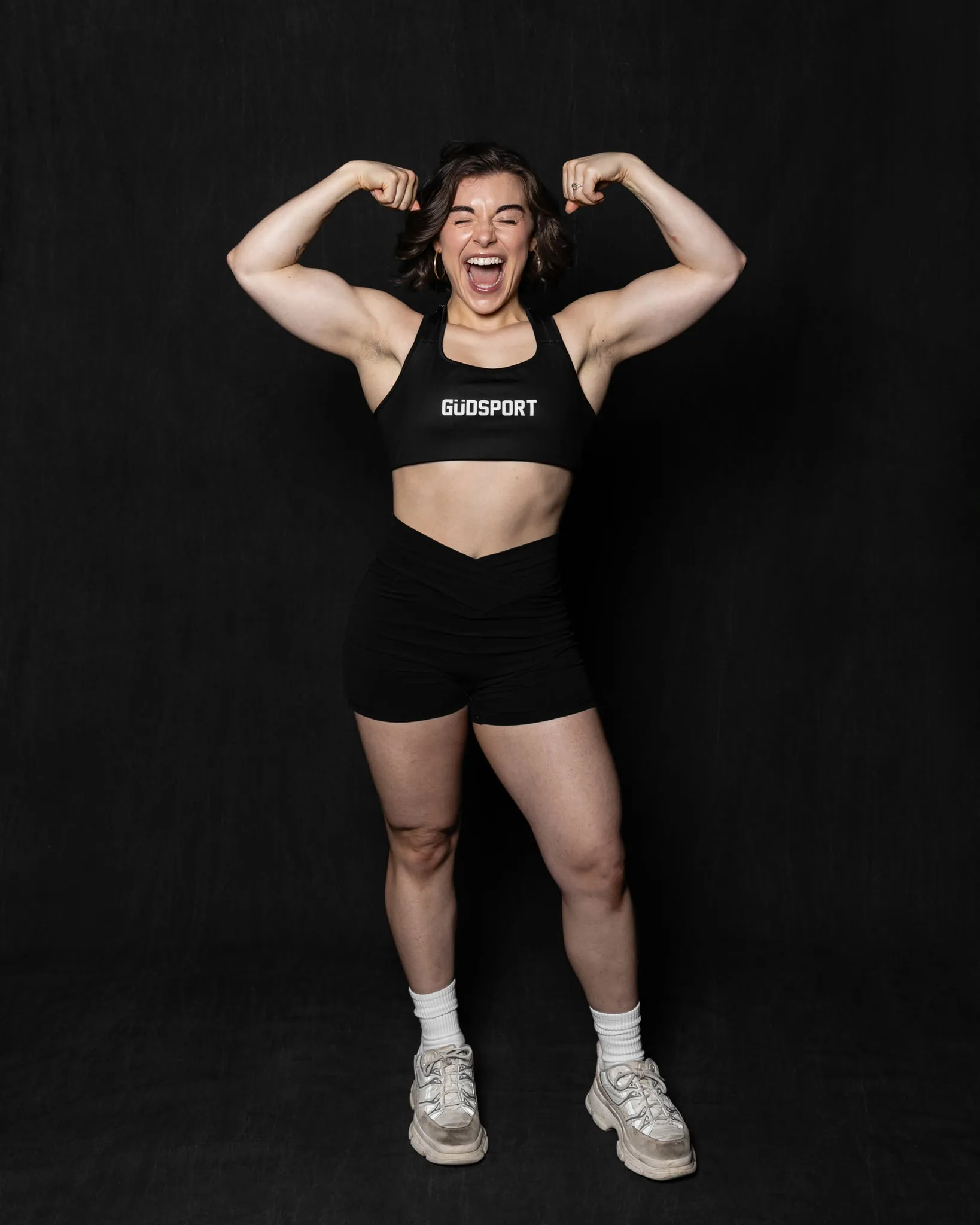 Coach Juliana flexing both arms