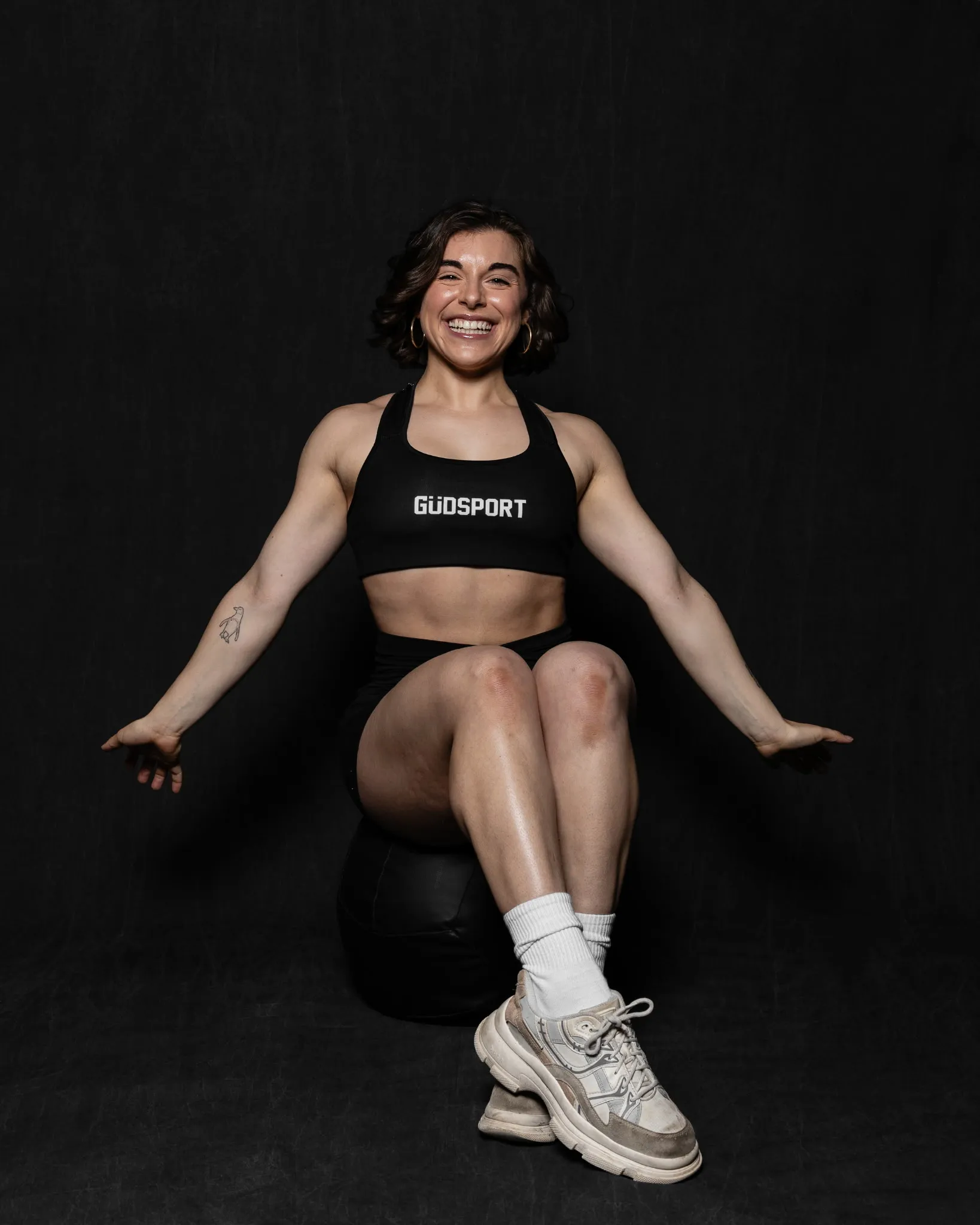 Coach Juliana smiling while seated on a medicine ball